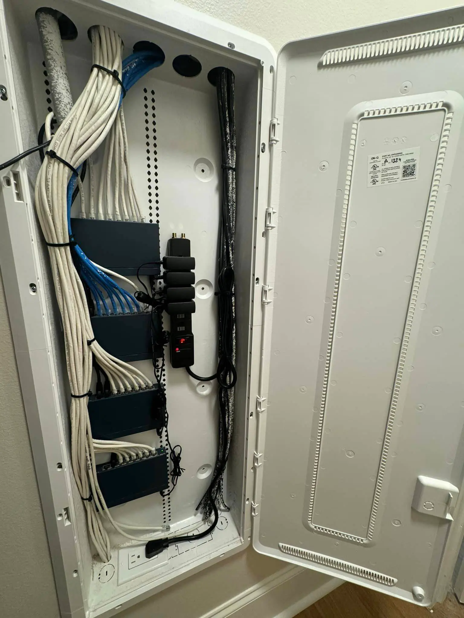 Labeled network and camera cables punched down on a patch panel in an equipment rack.
